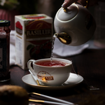Filiżanka i dzbanek sygnowany logiem Basilur. Basilur Forest Fruits - bezkofeinowa herbata w ekspresowych torebkach.