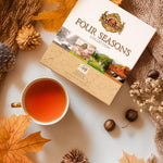 Zestaw herbat Basilur Four Seasons na stole obok filiżanki, jesienna sceneria